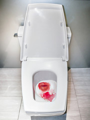 Blood in flush toilet, Medical issues concept concerning anal and sexual organ problems.