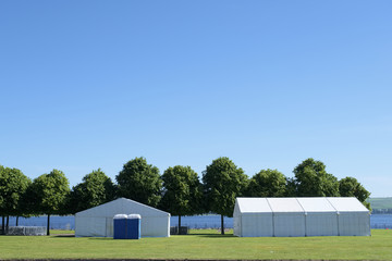 Fototapeta na wymiar Festival white tents marquee park summer blue sky uk