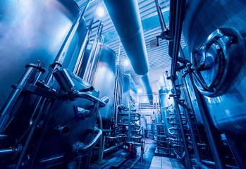 Modern interior of a brewery. Barrels and pipes. Factory interior.