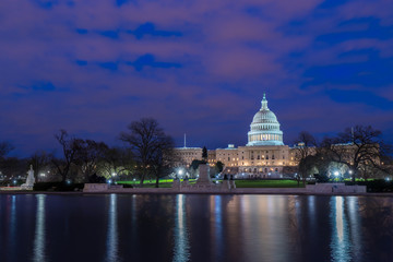The United States Capitol with reflection at night Washington DC USA