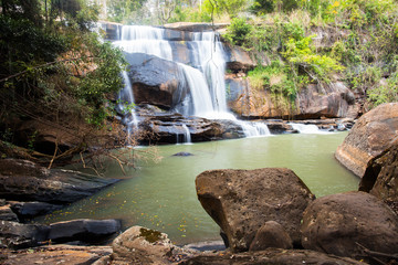 beautiful waterfall in forest with rock foreground