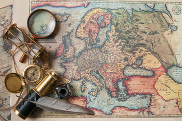 Fototapeta na wymiar Planning a trip: quill pen, old papers and maps with vintage items