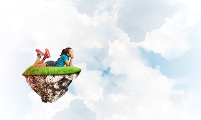 Concept of careless happy childhood with girl dreaming about something