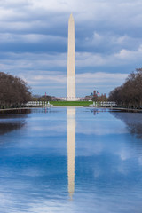 Washington Monument with reflection pool on a cloudy blue sky day, Washington DC, USA