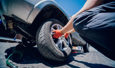 Obraz na płótnie Canvas Professional car mechanic replace tire on wheel.