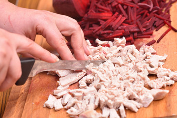 Sliced boiled turkey meat. Female hands with a knife cut boiled turkey meat