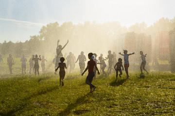 Happy children running through the spray of water
