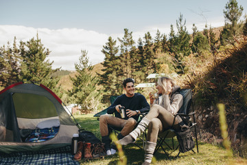 Couple camping in forest - obrazy, fototapety, plakaty