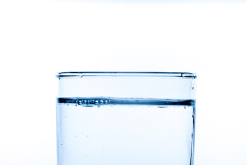 Close up pouring drinking water into glass, studio shot