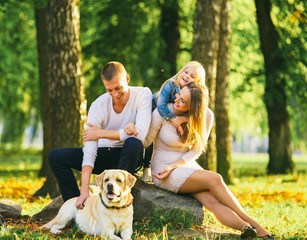 Fototapeta premium Happy family with their dog in the park on a sunny day