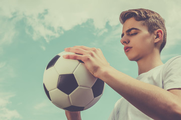 Happiness football player with ball and blue sky