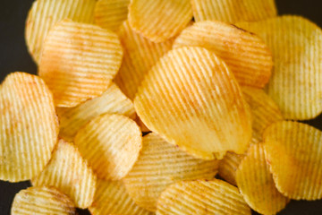 fast food. waved ridged chips recipe. golden fried spicy potato slices mix background