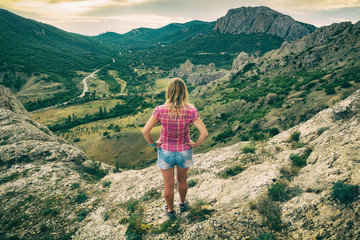 Girl standing on the edge of the cliff