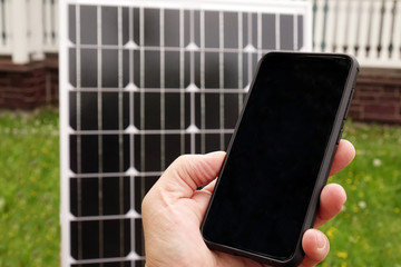 Smartphone and solar panel. Energy production technologies. Saving on renewable energy and solar panels.