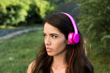 Young beautiful woman listening music with headphones outdoors