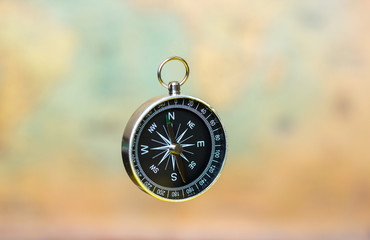 compass on a blurry background with a vintage world map