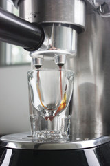 Espresso being poured into an espresso shot glass