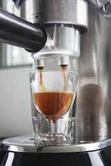 Espresso being poured into an espresso shot glass