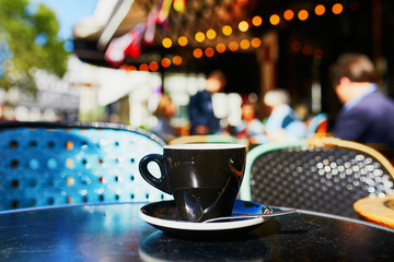 Cup of black coffee on a table of outdoor cafe