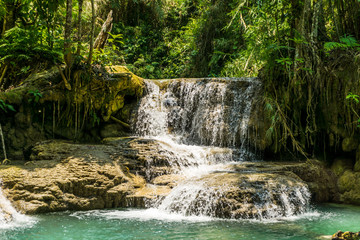 Naklejka premium Tad Kwang Si (Xi) the biggest water fall land mark in Luang Prabang, Laos ,beautiful turquoise color water at tropical forest in north Lao, for use as a background or travel advertisement image