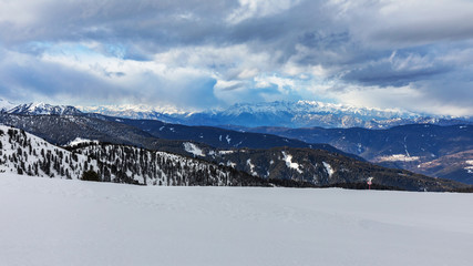 Fototapeta na wymiar Snowy mountain peaks in the Dolomites.. Empty ski slope in winter on a sunny day. Prepare ski slope, Alpe Cermis, Italy