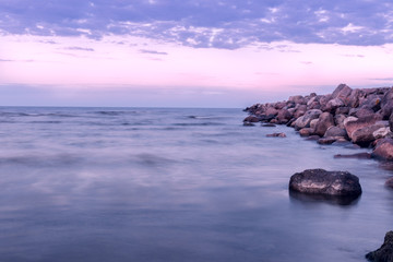 Fototapeta na wymiar Stone ridge extends into Baltic sea, long exposure, evening shot