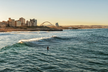 Obraz premium Surferzy cieszący się falami o zachodzie słońca