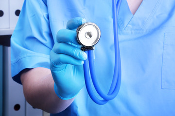 Closeup portrait of a doctor with a stethoscope on a background of a shelf with folders.
