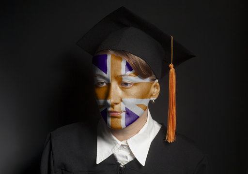 Portrait of Female British bachelor with painted British flag in Black mantle and Graduation Cap