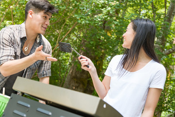 Multiethnic Young Adult Couple Having Fun Cooking At The Campground