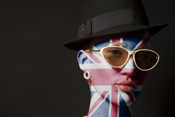 Portrait of woman with painted british flag and sunglasses