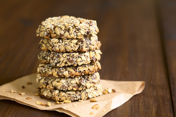 Vegan cookies made of banana, oatmeal and roasted oat grains, linseed, poppy seeds, grated coconut, chia seeds, photographed with natural light (Selective Focus on the front of the cookies)