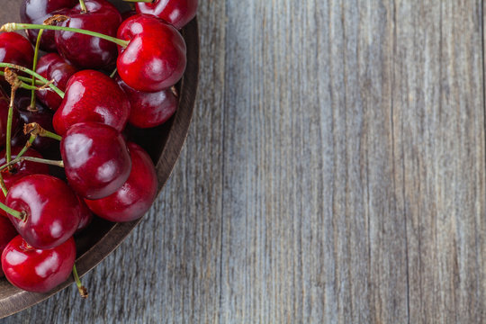 Fresh Ripe Cherries in a rustic wooden bowl