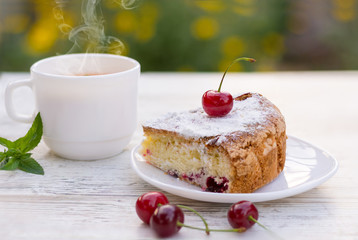 Вкусный кусок вишневого пирога на белой тарелке и белая чашка горячего чая с лимоном и мятой. Крупный план. Мокап.