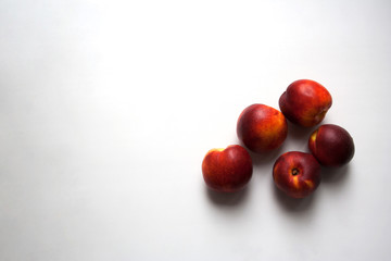 Five ripe nectarines isolated on white background from a high angle view and copy space