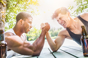 African American Man Arm Wrestling With Mixed Race Man Outdoors - obrazy, fototapety, plakaty