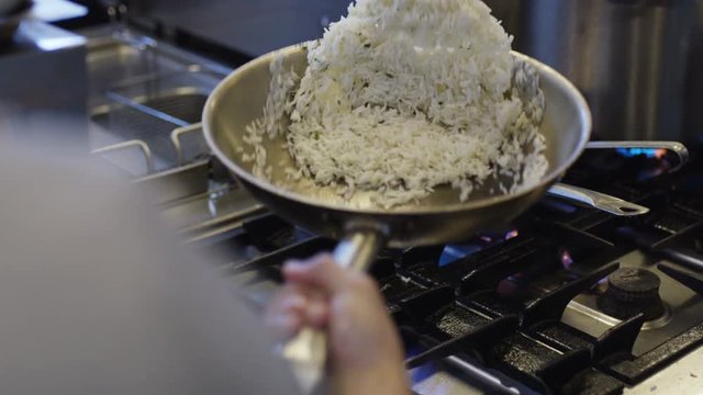  man cooking fried rice in a pan.
