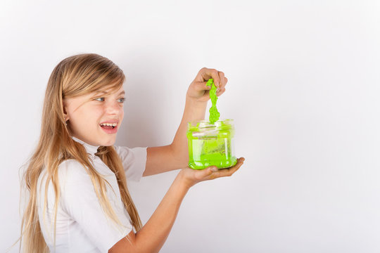 Girl pulling out a green slime from a plastic box