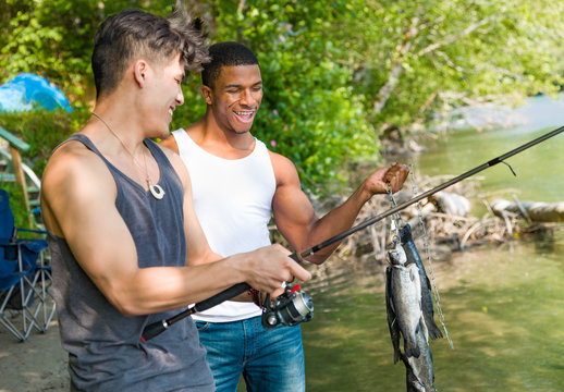 African American Man and Mixed Race Man Enjoying Fishing At The River
