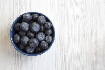 Blueberries in a blue bowl, top view. Organic superfood. Copy space.