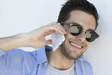 portrait of young with sunglasses talking on mobile phone