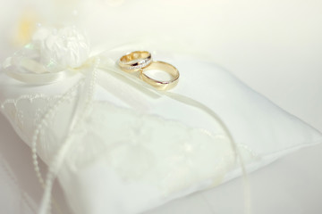 Wedding rings on white lace pillow