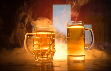 Creative concept. Beer glasses on table at dark toned foggy background with blurred view of flag of Switzerland. Support your country with beer concept.