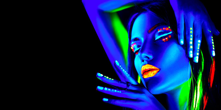 Fototapeta Fashion model woman in neon light, portrait of beautiful model girl with fluorescent makeup, Body art design in UV, painted face, colorful make up, over black background