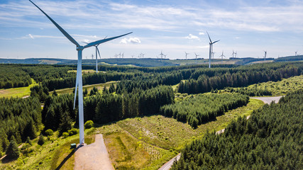 Aerial drone view of huge wind turbines spread across a highland area