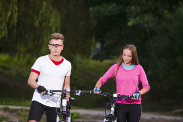 Couple of Caucasian Travellers Having a Stroll with Mountain Bikes Outdoors.