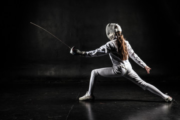 Fototapeta na wymiar Female fencer isolated on black background
