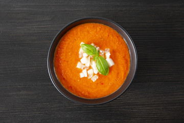 Soup gazpacho, Italian cuisine. Plate with soup in a black plate on a black background. Top  view Copyspace.