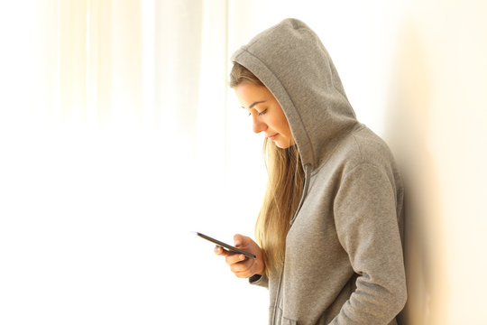 Teen reading messages in a phone at home