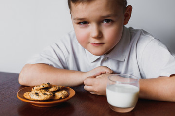 The boy looks with suspicion. Biscuits and milk.